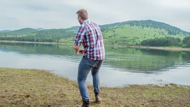 Man Throing Stones Lake Friends Spending Nice Day Water — Stock Video