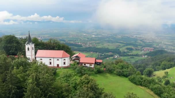 Hom Zeck スロベニア 2018年8月孤立した教会が丘の上に立ち 谷のいくつかの家を見下ろす 素敵な夏の日で 自然は美しく緑です — ストック動画