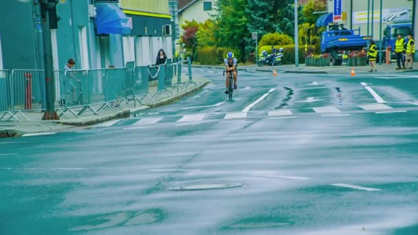 2つのロード自転車レースは反対方向に自転車に乗っています 雨のため道路は濡れて滑りやすい — ストック動画