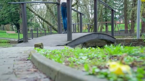 Una Joven Está Pie Puente Sobre Estanque Está Observando Naturaleza — Vídeo de stock