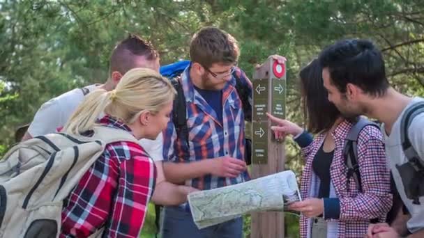 Freunde Überprüfen Etwas Auf Der Karte Und Auf Einem Wegweiser — Stockvideo