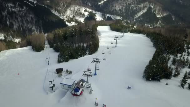 人々は丘の上まで椅子で移動している 空中射撃だスキーにはいい日だ — ストック動画