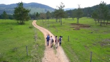 Turistler doğa yolunda yürüyorlar ve kırsal bölgeleri gözlemliyorlar..