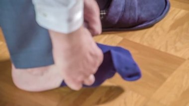 Damat ayaklarına çorap giydiriyor. Düğün töreni için hazırlanıyor..