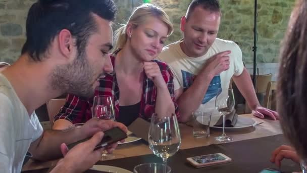 Друзья Сидят Столом Ресторане Проверяют Чьему Телефону Ждут Прибудет Еда — стоковое видео
