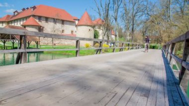 Kalenin yakınındaki köprüde bisiklet süren genç bir adamın görüntüleri.