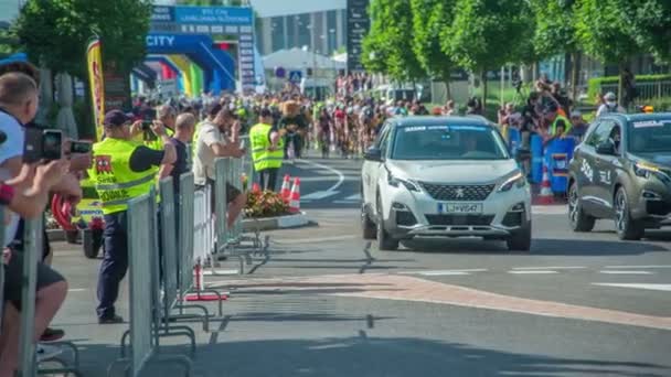 クマのマスコットと車のカップルは すべての道路自転車レーサーの前にあります マラソンが正式にスタートしました — ストック動画