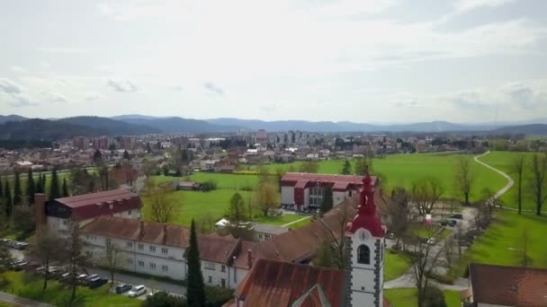 一座修道院和一座教堂坐落在一个绿色的大草坪旁边 还有一个村庄在后面 — 图库视频影像