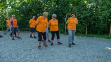 DOMZALE, SLOVENIA - 21. HAZİRAN 2015 Bir grup son sınıf öğrencisi birlikte yürürken bacaklarını mümkün olduğunca yukarı kaldırmaya çalışıyor..