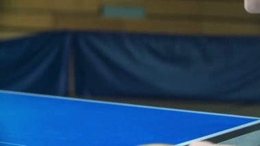 Kızlar okulun spor salonunda masa tenisi oynarken eğleniyorlar. Beden eğitimi alıyorlar..