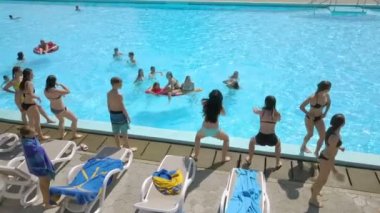 DOMZALE, SLOVENIA - 20. Haziran 2015 Bazı kızlar havuz kenarında dans ediyor ve diğerleri yüzüyor ya da sadece takılıyor. Gerçekten güzel bir yaz günü..