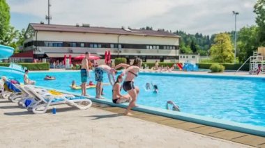 DOMZALE, SLOVENIA - 20. Haziran 2015 'te bir kız koşuyor ve suya atlıyor. Güzel bir yaz günü. Güneş parlıyor..