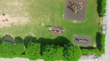 Çocukların okul dışında oynadığı güzel bir yeşil park. Güzel bir yaz günü. Salıncakta sallanarak eğleniyorlar..