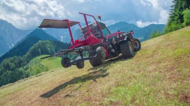 Arka planda bir traktör ve muhteşem dağlar. Hava güneşli ve sıcak. Yaz zamanı..