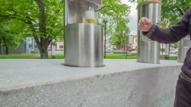 ZALEC, SLOVENIA 10 HAZİRAN 2017 Kupa bira dolu. Bir adam onu alır ve içmeye başlar. Parkta bira içen birkaç kişi daha var..