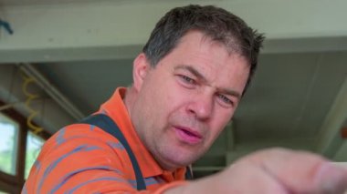 Bir marangoz tasarladığı eski ahşap arabanın yüzeyini öğütüyor ve iyi olduğundan emin olmak için nazikçe yüzeye dokunuyor..