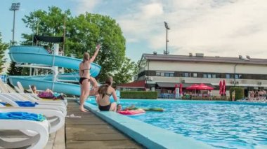 DOMZALE, SLOVENIA - 20. HAZİRAN 2015 Genç bir kız yüzme havuzunun diğer tarafında duran birine el sallıyor.