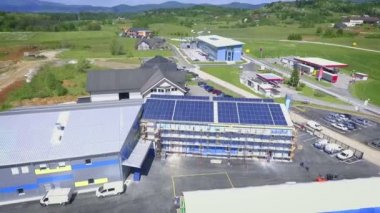 Güneş panelleri fabrikanın tüm çatısında. Etrafta bir sürü doğa var..
