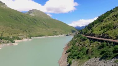 İsviçre 'de güneşli bir günde güzel mavi nehir ve barajın hava görüntüleri.