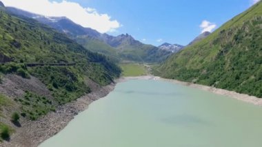 İsviçre 'de güneşli bir günde güzel mavi nehir ve barajın hava görüntüleri.