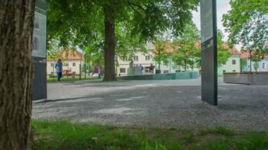 ZALEC, SLOVENIA 10 HAZİRAN 2017 Bir parkın ortasında yeşil altın çeşmesi duruyor. Yaşlı bir adam geçiyor..
