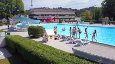 DOMZALE, SLOVENIA - 20. Haziran 2015 havuz kenarında takılan ya da havuzda yüzen gençler. Sıcak bir yaz günü. Hava görüntüsü.