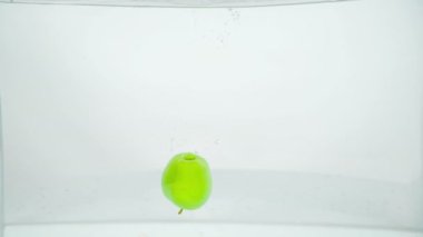 Güzel yeşil bir elma suya düşer ve yüzeyde kalır..