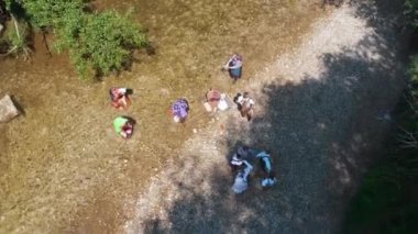 Çocuklar birbirlerinin ellerini tutuyorlar ve daireler çizerek dans ediyorlar. Hava görüntüsü. Güzel ve güneşli bir gün..