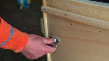 Bir adam kapı koluna dokunuyor ve arabasının kapısını kapatıyor. Arabanın kapısının sorunsuzca açılıp kapandığından emin oluyor..