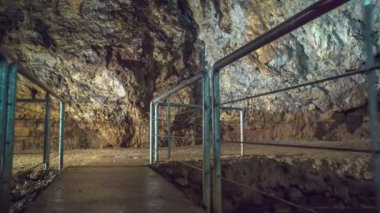 ZALEC / CELJE, SLOVENIA - 18. Mayıs 2017 Bir mağarada her iki taraftan da korunan kaygan dar bir yol. Böylece ziyaretçiler özgürce ve güvenli bir şekilde üzerinde yürüyebilecekler..