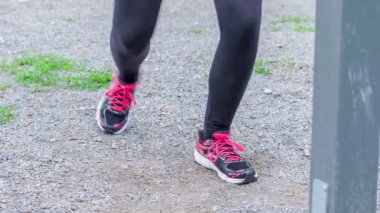 Genç bir kız bacakları için egzersizlerle birlikte bazı kardiyo egzersizleri yapıyor. O dışarıda çalışıyor..