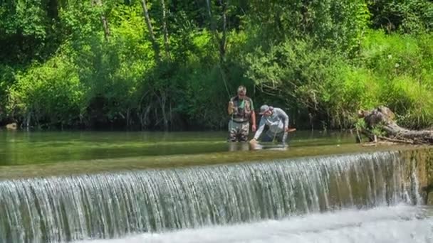 2人の漁師は川の急流の近くに立っており 釣りをしている 天気は本当にいいですね — ストック動画