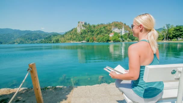 Uma Mulher Bonita Está Sentada Banco Branco Perto Lago Bled — Vídeo de Stock