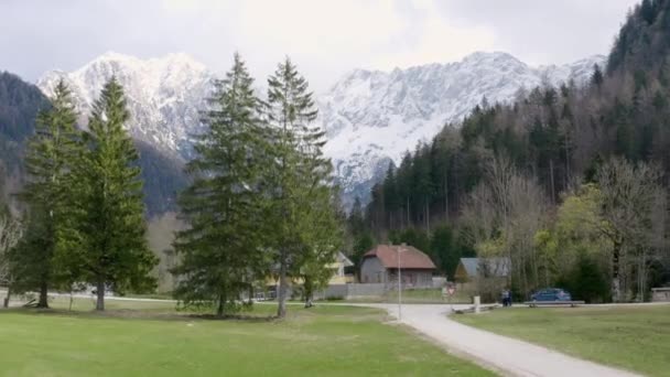 Piękna Zielona Dolina Zaledwie Kilkoma Domami Górami Pokrytymi Śniegiem — Wideo stockowe