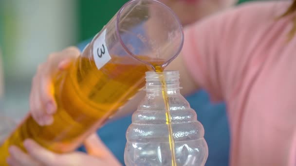 Alguien Está Vertiendo Líquido Amarillo Una Botella Otra Los Niños — Vídeo de stock