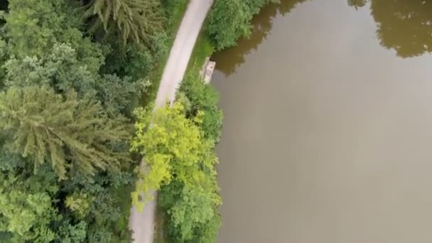 Hombre Está Montando Bicicleta Camino Angosto Junto Lago Disparo Aéreo — Vídeos de Stock