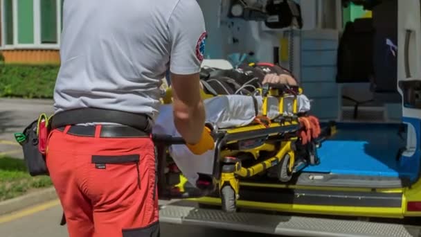 一个医疗人员小组正在把一名伤员从救护车上拖下来 她在担架上 — 图库视频影像