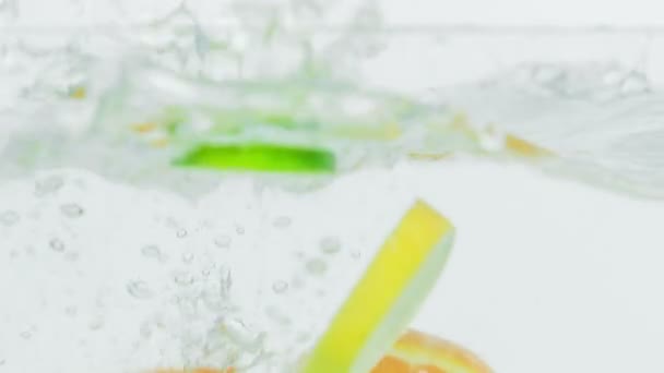 Några Citron Lime Och Orange Bitar Faller Vattnet Och Simmar — Stockvideo