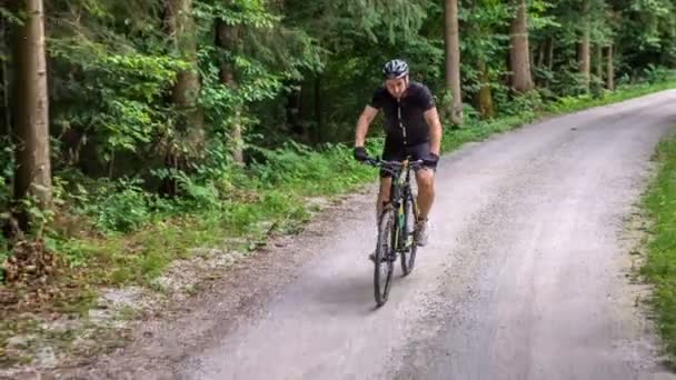 Deportista Está Montando Lentamente Bicicleta Sendero Forestal Está Mirando Alrededor — Vídeos de Stock