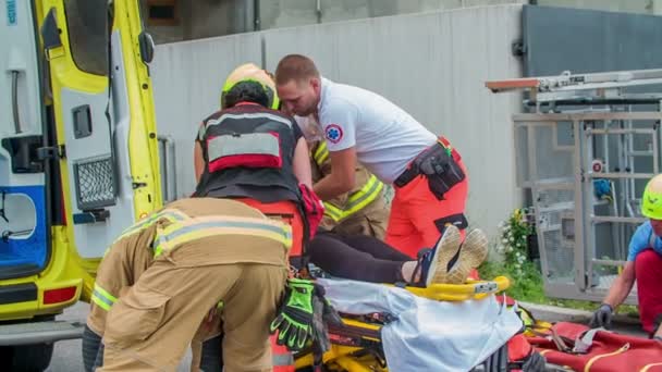 Ett Team Brandmän Och Medicinsk Personal Hjälper Skadad Person Och — Stockvideo