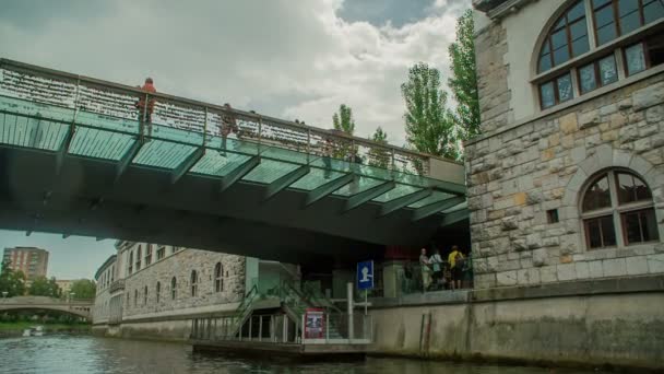Egy Fahajó Vitorlázik Ljubljanica Folyón Közeledik Hídhoz Ahol Turisták Állnak — Stock videók