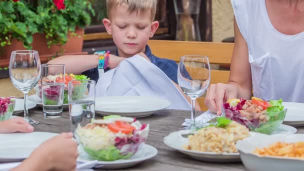 Chłopak Próbuje Włożyć Serwetkę Pod Koszulę Zanim Zacznie Jeść Lunch — Wideo stockowe