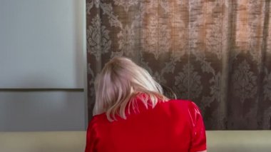 Genç bir kadın erkeğinin üstünde oturuyor ve kırmızı elbiseler giyiyor. Neredeyse sevişiyorlardı..