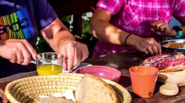 İki kişi yemeklerini yiyor. Dışarıda oturuyorlar ve önlerinde bir sürü lezzetli yemek var..