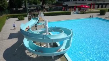 DOMZALE, SLOVENIA - 20. Haziran 2015 'te genç çocuklar su kaydırağından aşağı inerken eğleniyorlar. Aynı zamanda akranlarıyla vakit geçirmekten de zevk alıyorlar..