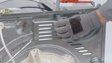 Servis merkezindeki çamaşır makinesinin yakın çekim görüntüleri.