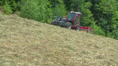 Traktörlü genç bir adam sarp bir tepe hazırlamaya başlıyor. Hava güneşli..