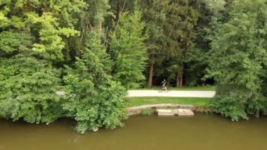 Genç bir sporcu zamanını dışarıda geçiriyor ve biraz spor yapıyor. Manzara güzel ve yeşil. Hava görüntüsü.