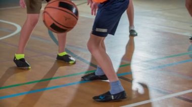 Turuncu takım çok eğleniyor. Çocuklar okulun spor salonunda basketbol oynuyorlar..