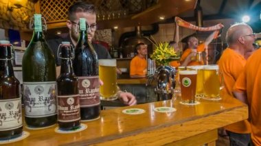 DOMZALE, SLOVENIA - 16. Temmuz 2018 'de bir barmen tezgahın üzerine birkaç sürahi bira koyuyor. Taraftarlar bu gece çok içiyor ve iyi vakit geçiriyorlar..